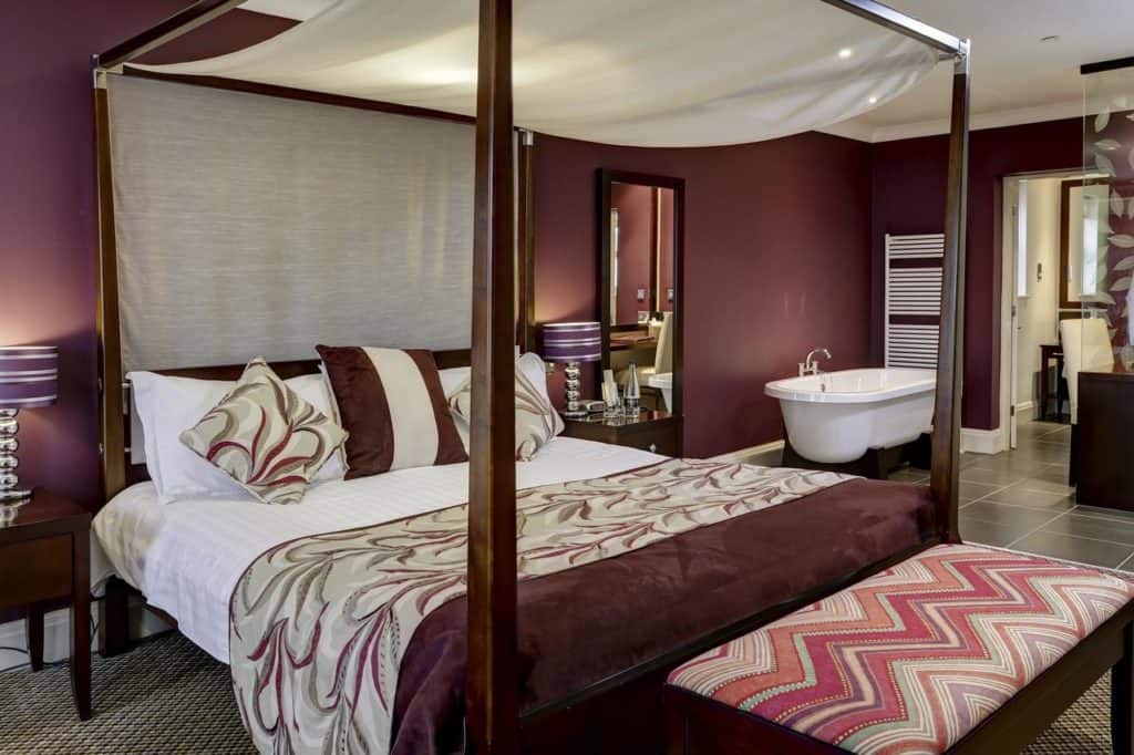 Inside a  Deluxe Double Room for a family of 3 with four-poster bed and a bath tub in the bedroom at The Best Western Forest & Vale Hotel