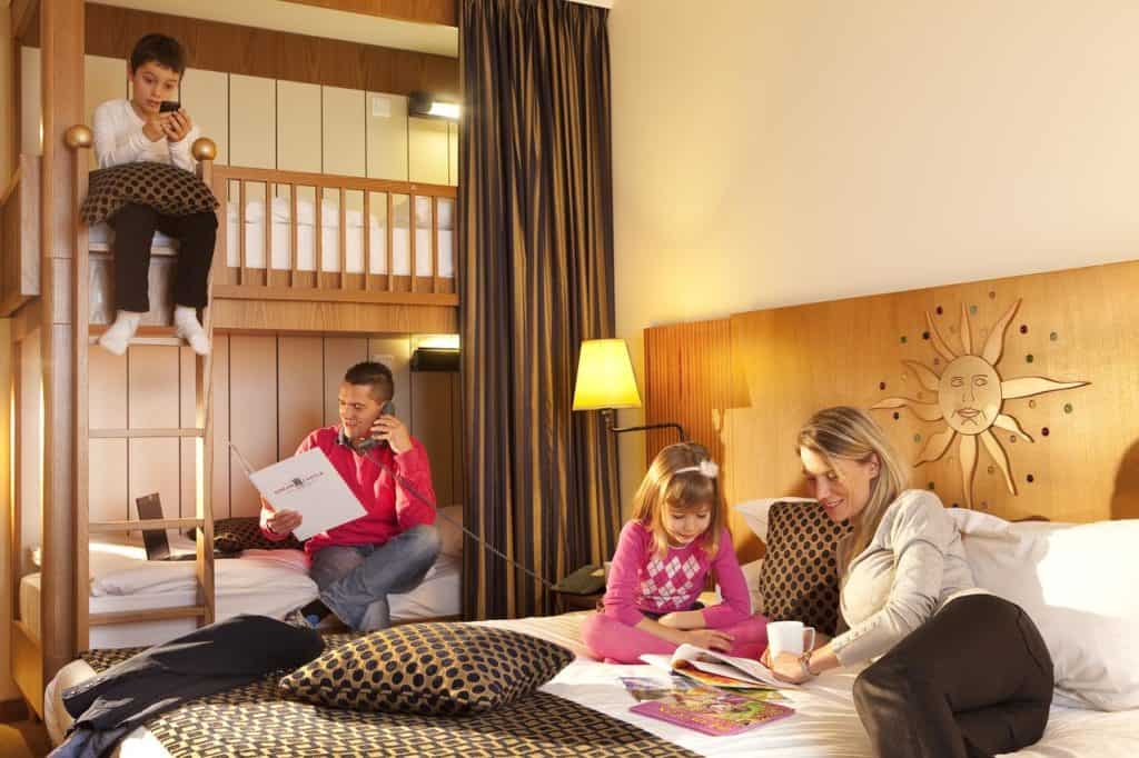 A family of 4 relaxing inside a cozy kid-friendly room at Vienna House Dream Castle Marne La Vallee