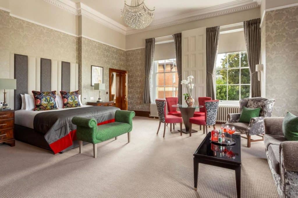 Inside a luxurious and regal room with chandelier, sofa set, and glass tea table at Oulton Hall