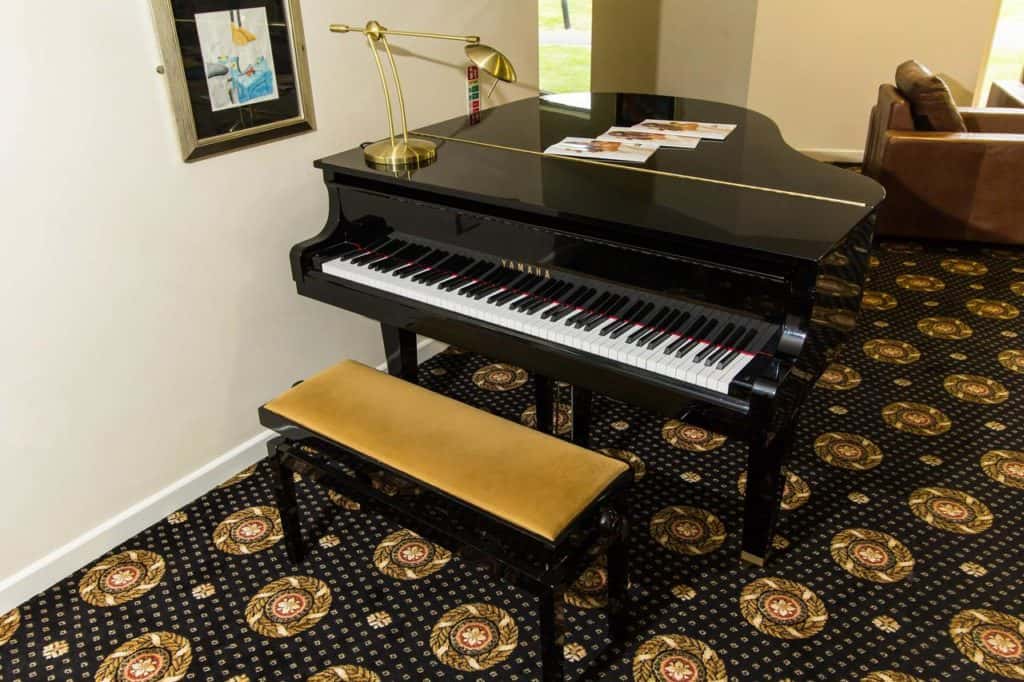 Black grand piano inside family-friendly Padbrook Park Hotel near to Diggerland