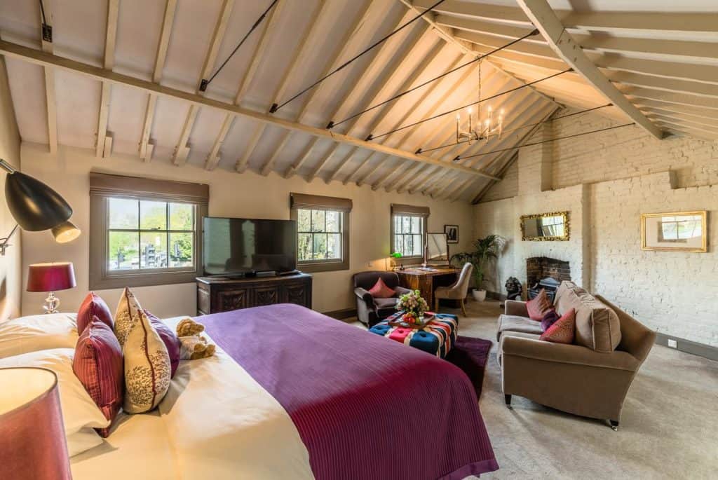 Inside a quirky and colorful family room with exposed beams, sofa set, and couch at York & Albany