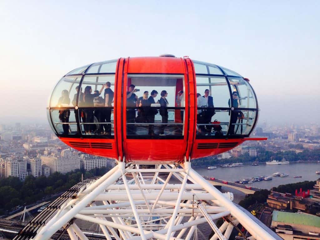 families taking photos while riding the london eye