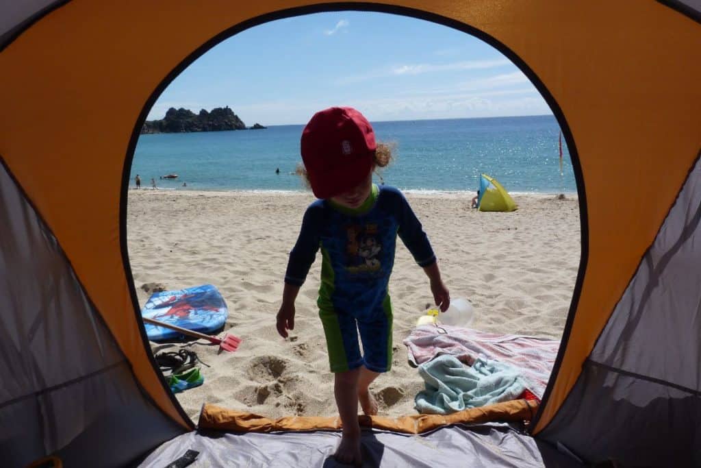 Child walking into their beach tent