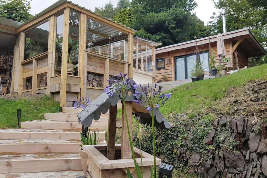 The wishing well and steps leading to the hut. Also showing the viewing area of the bar/chill out space.