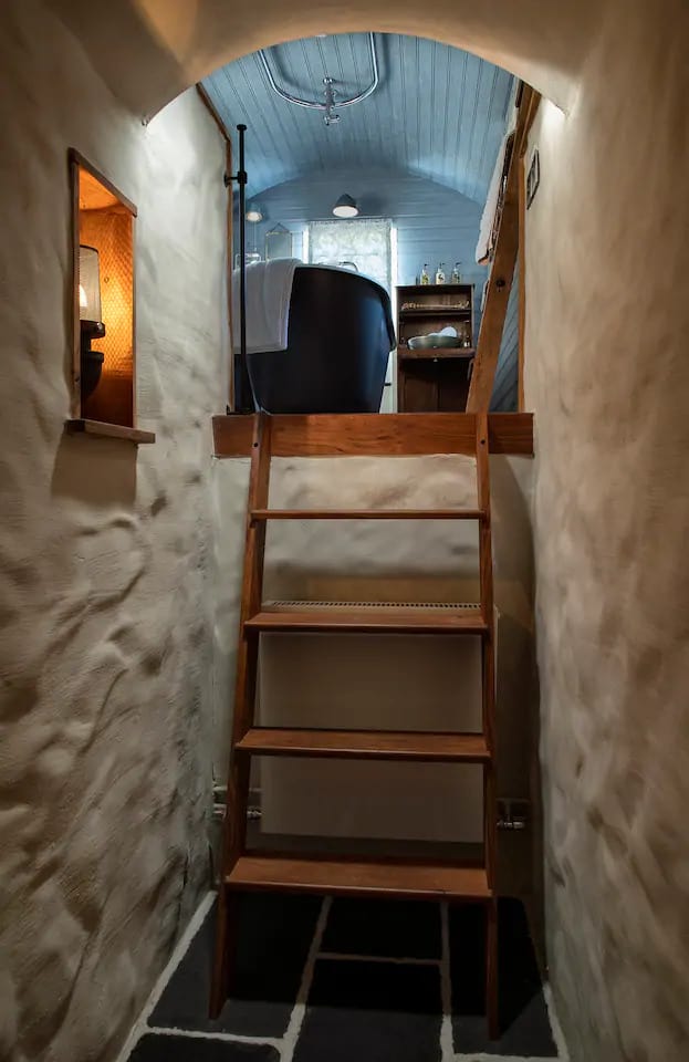 Climb up into the bedroom and bathroom from the passageway on bespoke wooden ladders.