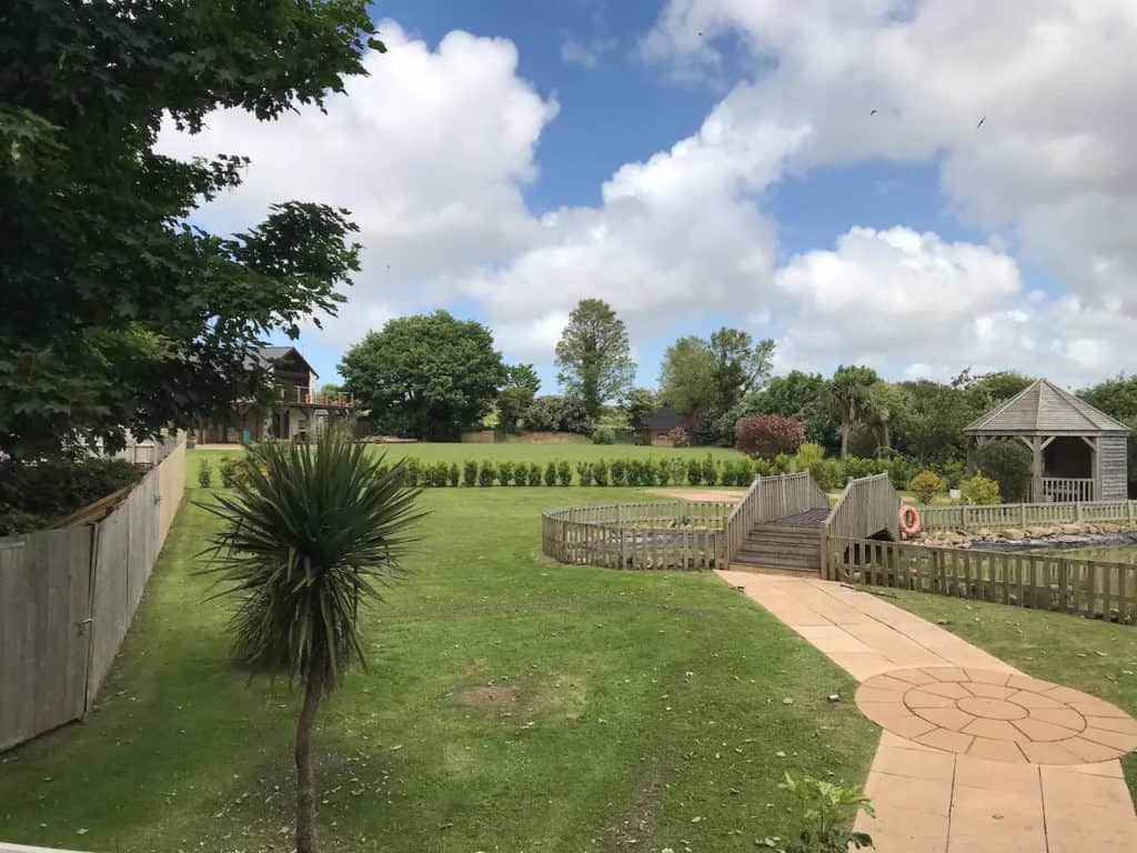 The view from the balcony. Guests at Treetops have use of the garden up to and not beyond the row of bushes. At the top of the garden is the house used as a holiday let.